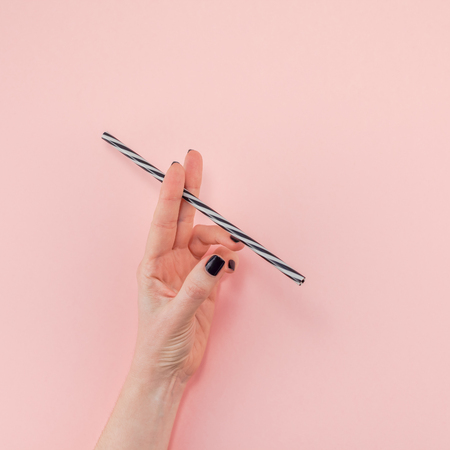 Woman holding a drinking straw like a cigaretteの写真素材