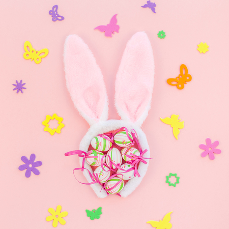 Creative Top view flat lay holiday composition Easter eggs bunny ears spring flowers on pink paper background copy space Template Easter day seasonal patternの写真素材