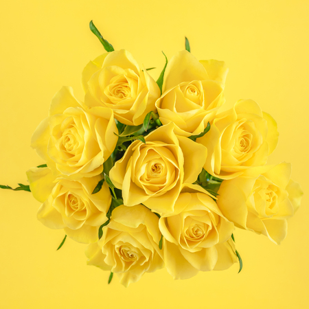 Creative top view flat lay fresh yellow roses bouquet with copy space bold color paper background minimalism style. Template feminine blog social media holiday wedding invitation cardの写真素材