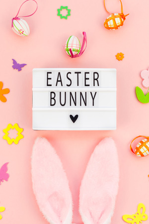 Creative Top view flat lay holiday composition Easter bunny text on lightbox pink paper background copy space Template Easter day seasonal patternの写真素材