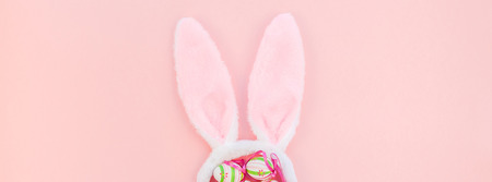 Creative Top view flat lay holiday composition Easter eggs bunny ears spring flowers on pink paper...
