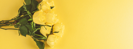 Creative top view flat lay fresh yellow roses bouquet with copy space bold color paper background minimalism style. Template feminine blog social media holiday wedding invitation cardの写真素材