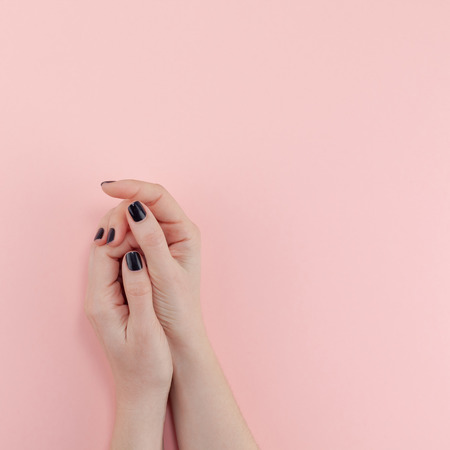 Stylish trendy female black manicure. Beautiful young woman's hands on millennial pink pastel background. Beauty and SPA concept. Square Template for feminine blog social mediaの写真素材