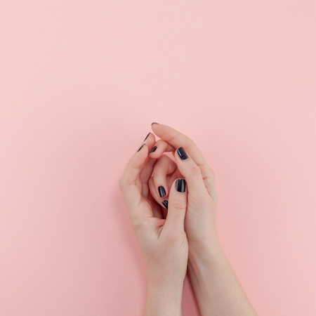 Stylish trendy female black manicure. Beautiful young woman's hands on millennial pink pastel background. Beauty and SPA concept. Square Template for feminine blog social mediaの写真素材