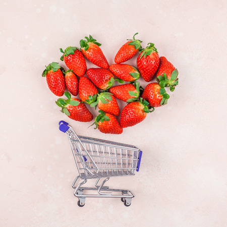Creative Shopping concept composition flat lay top view love holiday celebration with red strawberries pink background copy space Template sale promotion text social media blogsの写真素材
