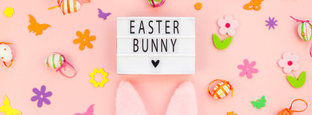 Creative Top view flat lay holiday composition Easter bunny text on lightbox pink paper background...