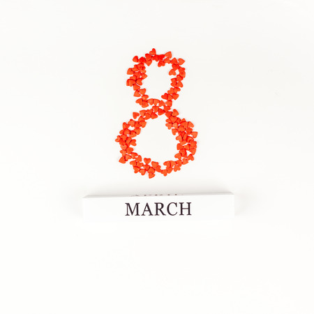 Creative flat lay top view 8 March International Women's Day greeting card with small red hearts on...