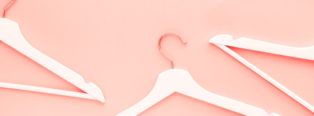 Creative top view flat lay wooden hangers toned living coral color of the year 2019 long banner copy space minimalism style. Template fashion blog social media sale store promo design shopping conceptの写真素材