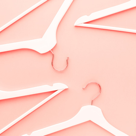 Creative top view flat lay wooden hangers toned living coral color of the year 2019 background copy space minimalism style. Template fashion blog social media sale store promo design shopping conceptの写真素材