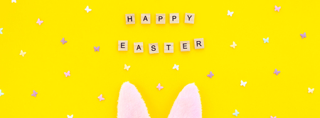 Creative Top view flat lay holiday composition Easter bunny ears eggs text message on bold yellow...