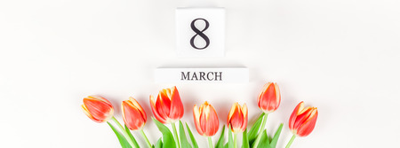 Creative flat lay top view 8 March International Women's Day greeting card with red tulips spring...