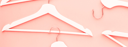 Creative top view flat lay wooden hangers toned living coral color of the year 2019 long banner copy space minimalism style. Template fashion blog social media sale store promo design shopping conceptの写真素材