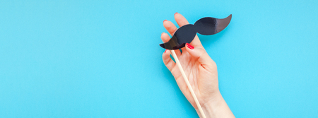 Creative flatlay top view retro black paper photo booth props moustaches woman hands turquoise background copy space. Men health awareness month fathers day masculinity concept Long wide bannerの写真素材