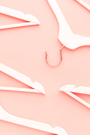Creative top view flat lay wooden hangers toned living coral color of the year 2019 background copy space minimalism style. Template fashion blog social media sale store promo design shopping conceptの写真素材