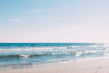 Summer sand beach and seashore waves background. Defocused holiday vacations concept backdrop for motivational quotes, blog posts, your textの写真素材