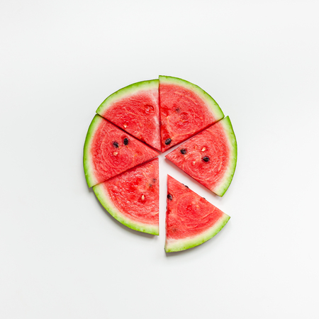 Creative scandinavian style flat lay top view of fresh watermelon slices on white table background copy space. Minimal summer fruits creative for blog or recipe bookの写真素材