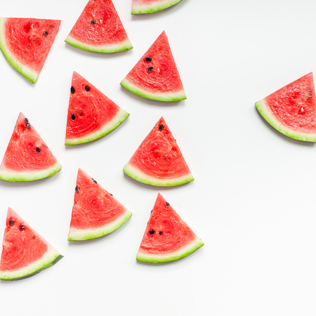 Creative scandinavian style flat lay top view of fresh watermelon slices on white table background copy space. Minimal summer fruits pattern for blog or recipe bookの写真素材