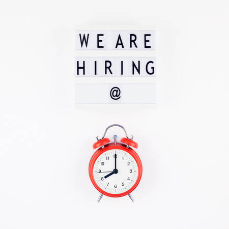 Creative top view flat lay of desk with we are hiring text on lightbox with copy space on white...