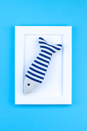 Creative flat lay concept of summer travel vacations. Top view of seashells and starfish on turquoise blue background with white frame mock up and copy space in minimal style, template for textの写真素材