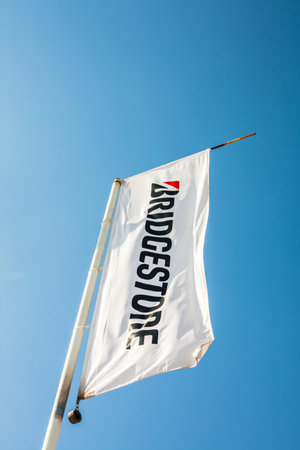 SAGUNTO, SPAIN - FEBRUARY 18, 2019: Bridgestone flag with logo on clear blue sky background located in Sagunto, Spainのeditorial素材