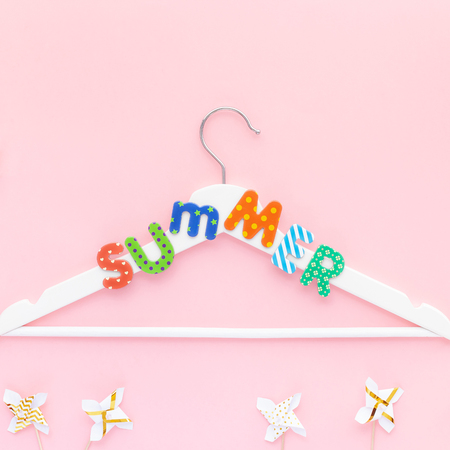 Creative top view flat lay white wooden hangers summer text pastel pink background copy space minimalism style. Template fashion feminine blog social media sale store promo design shopping conceptの写真素材