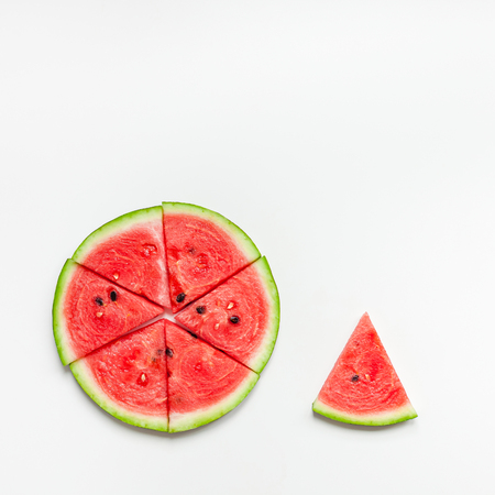 Creative scandinavian style flat lay top view of fresh watermelon slices on white table background copy space. Minimal summer fruits creative for blog or recipe bookの写真素材