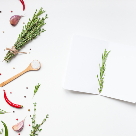 Flat lay overhead view blank notebook pages mockup text space invitation card on white background with greens herbs and spices. Menu or recipe book or food blog design with cooking ingredientsの写真素材