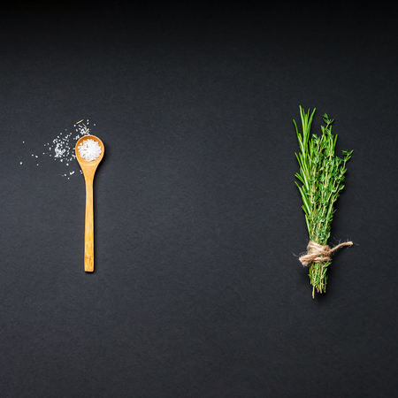 Flat lay overhead top view of greens herbs and spices on black background with copy space. Menu frame design food pattern background with cooking ingredientsの写真素材