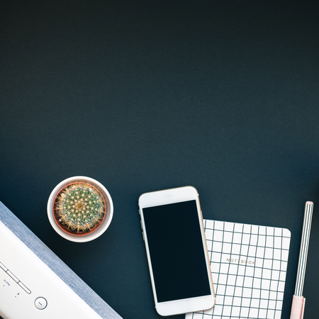 Top view flat lay of feminine desk workspace with white stereo bluetooth soundbar and smartphone for music listening with copy space on black background. Template for blog social mediaの写真素材