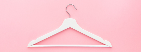 Creative top view flat lay white wooden hangers pastel millennial pink background with copy space minimalism style. Template fashion feminine blog social media sale store promo design shopping conceptの写真素材