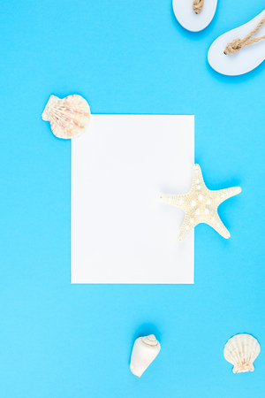 Creative flat lay concept of summer travel vacations. Top view of seashells and starfish on turquoise blue background with postcard mock up and copy space in minimal style, template for textの写真素材