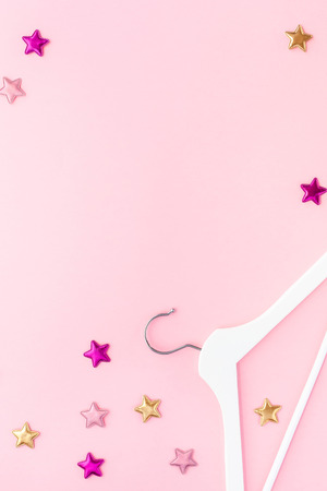 Creative top view flat lay white wooden hangers pastel millennial pink background with copy space minimalism style. Template fashion feminine blog social media sale store promo design shopping conceptの写真素材