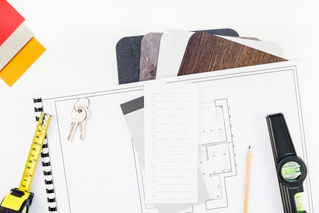 Creative flat lay overhead top view blueprint flat project plan and office supplies on decorator table workspace swatches tools and equipment background copy space conceptの写真素材