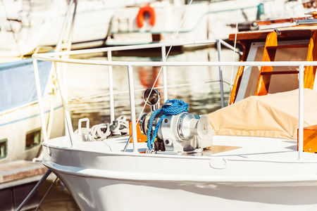 Recreational yacht detail with ropes and other equipment. Filtered shot with sun reflection in...