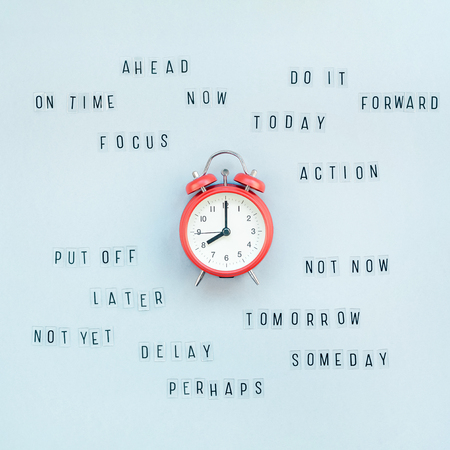 Creative top view flat lay of alarm clock with messages about delay or starting doing task copy space blue background minimal style. Concept of procrastination, time management in business and lifeの写真素材