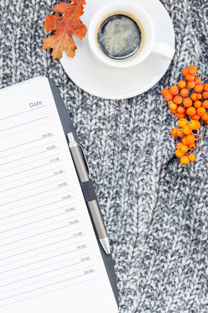Creative autumn flat lay overhead top view stylish home workspace with planner organizer coffee cup cozy gray knitted plaid background copy space. Fall season template for feminine blog social mediaの写真素材