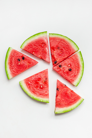 Creative scandinavian style flat lay top view of fresh watermelon slices on white table background copy space. Minimal summer fruits creative for blog or recipe bookの写真素材