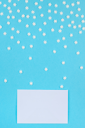 Creative Top view flat lay winter frame. Concept Mockup pattern made of small white snowflakes letter envelope pastel blue background copy space minimalism Template anniversary design invitation cardsの写真素材