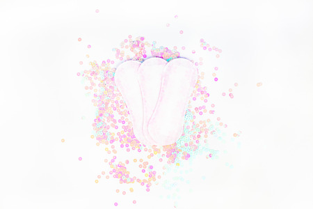 Daily sanitary napkins on white background and pearl pastel confetti sparkles with copy space. Creative female healthcare concept top view flat lay for your blog, text or designの写真素材