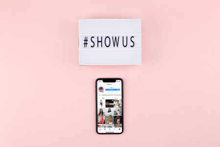 BERLIN, GERMANY - APRIL 04, 2019: Illustrative editorial image of lightbox hashtag Show Us message mobile phone with instagram screenshot pink background.のeditorial素材