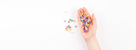 Creative flat lay back to school education concept with woman hand and multicolor letters isolated on white background with copy space, template for text or designの写真素材