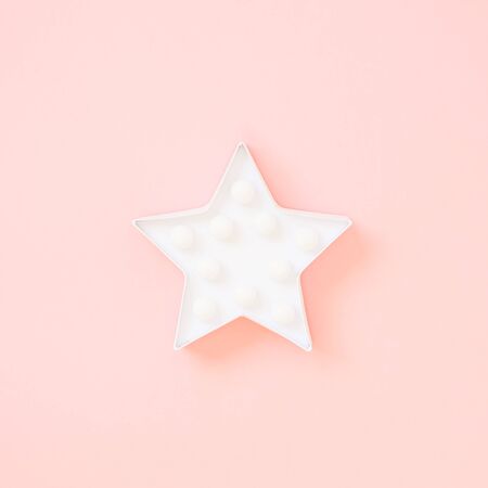 Star shaped white LED lights lamp single frame. Creative conceptual top view flat lay square composition with copy space on pink background in minimal styleの写真素材