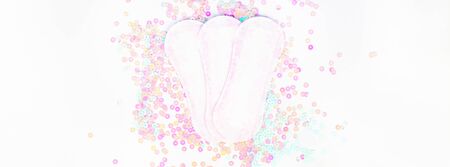 Daily sanitary napkins on white background and pearl pastel confetti sparkles with copy space....