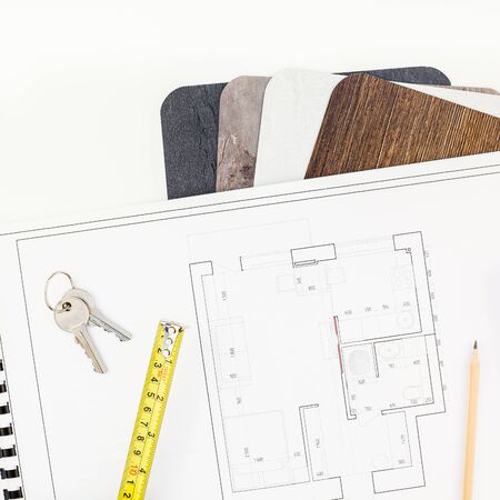 Creative flat lay overhead top view blueprint flat project plan and office supplies on decorator table workspace swatches tools and equipment background copy space conceptの写真素材