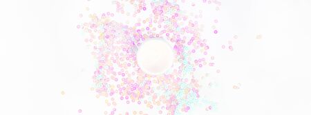 Cosmetic cream lotion jar on white pearl pastel confetti sparkles background with copy space....