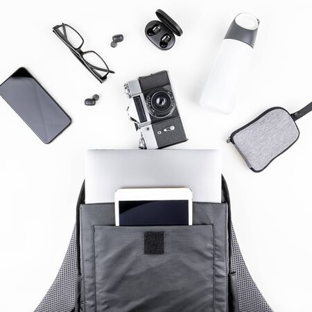 Creative top view flat lay of open backpack with laptop and tablet inside, mobile phone, copy space...