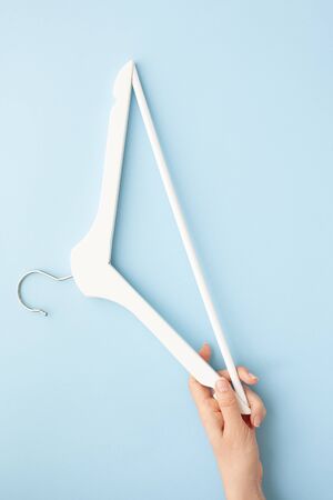 Creative top view flat lay white wooden hangers isolated pastel blue background with copy space minimalism style. Template fashion feminine blog social media sale store promo design shopping conceptの写真素材