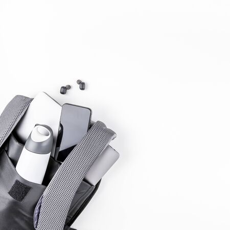 Creative top view flat lay of open backpack with laptop and tablet inside, mobile phone, copy space...