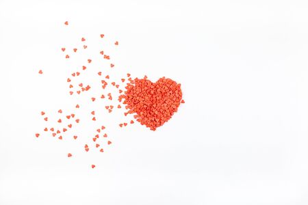 Valentine's Day. Creative holiday concept of love made from broken red heart shaped flying sweet confetti. Valentines day top view on white background.の写真素材