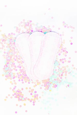 Daily sanitary napkins on white background and pearl pastel confetti sparkles with copy space. Creative female healthcare concept top view flat lay for your blog, text or designの写真素材